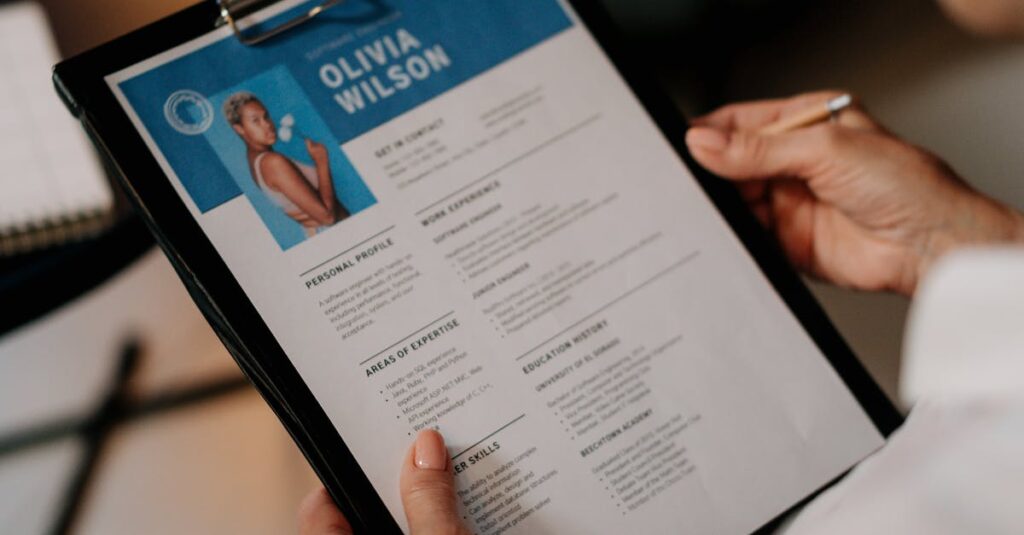 An HR professional reviews a resume on a clipboard during an office meeting.