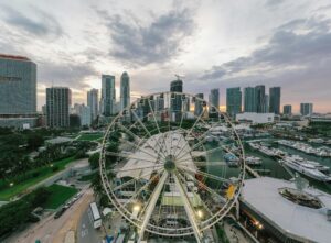 A breathtaking aerial view of Miami featuring a ferris wheel against the city skyline and harbor at sunset.